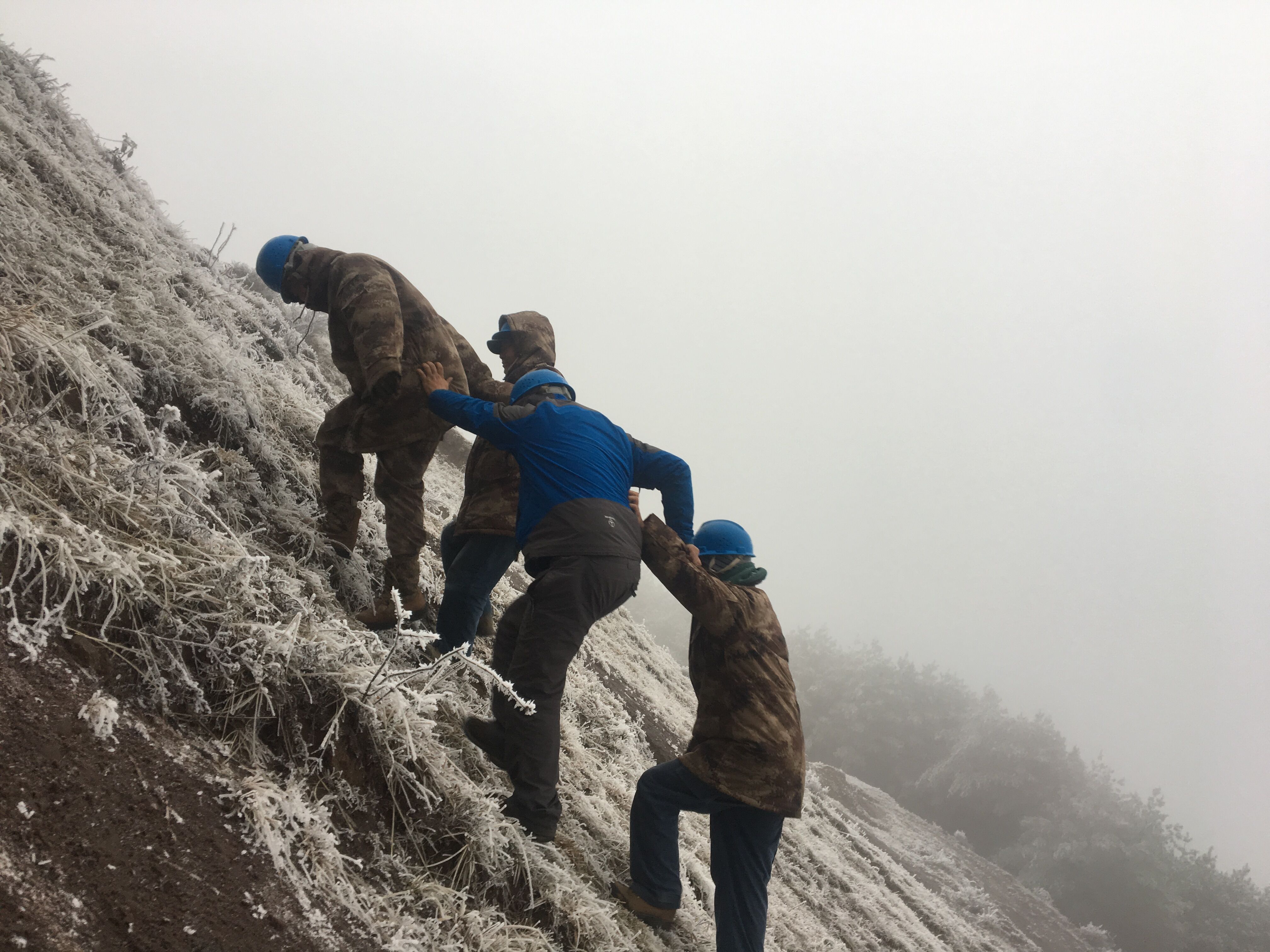 互相攙扶，勇登高峰。（李健攝）